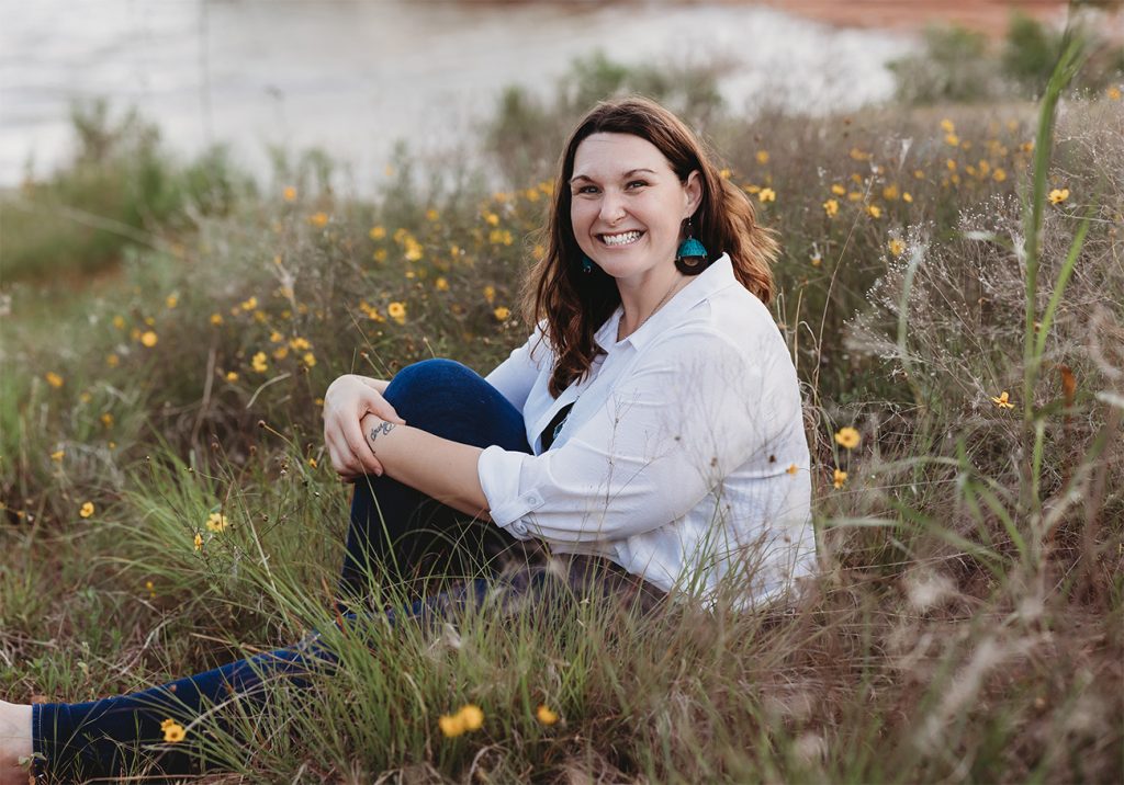Jenn Bierma sitting in a field of wildflowers